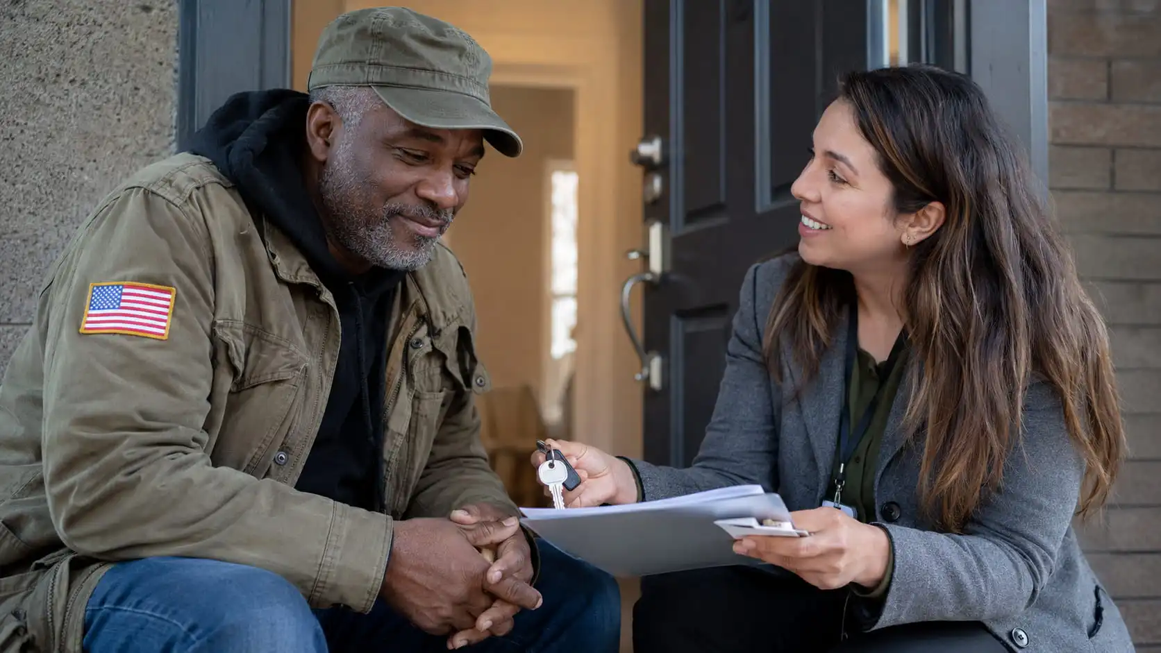 Veteran receiving keys to a new home from a housing support professional